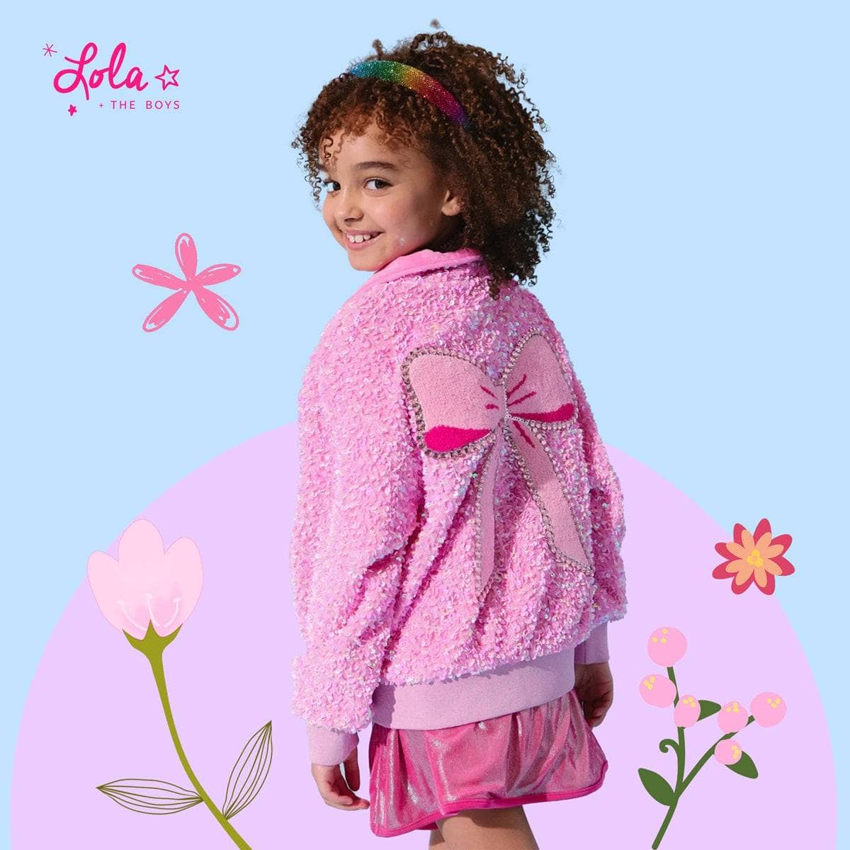 Girl wearing a pink sequin bomber jacket smiling confidently