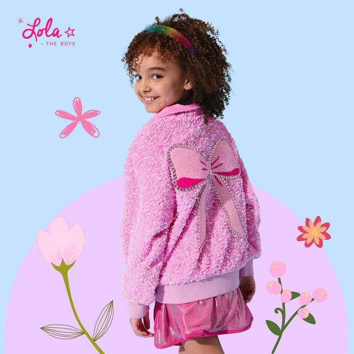 Girl wearing a pink sequin bomber jacket smiling confidently